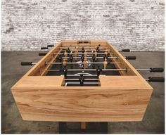 the foosball table is made out of wood and has black handles on it