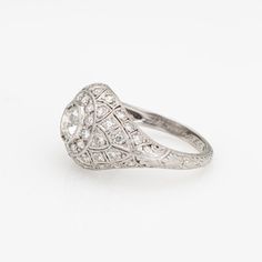 This is part of Chairish’s Fine Jewelry assortment.  Finely detailed vintage Art Deco diamond ring (circa 1920s to 1930s) crafted in 900 platinum.   Center set old European cut diamond is estimated at 0.60 carats, accented with an estimated 0.40 carats of single cut diamonds. The total diamond weight is estimated at 1 carat (estimated at I-J color and VS2-SI2 clarity).    The stylish Art Deco era ring features a sparkling old European cut diamond to the center, with smaller single cut diamonds set into the mount. With fine mile grain and hand etched palmette details, the ring is a feast for the eyes. The inner band is engraved "J.E.W to R.E.S". The ring would make a lovely vintage alternative engagement or wedding band or right hand ring for everyday wear. The ring has a lower domed profil 1ct Diamond Ring, White Engagement Ring, Art Deco Diamond Ring, Deco Diamond Ring, Victorian Engagement Rings, Contemporary Engagement Rings, Minimalist Engagement Ring, Platinum Diamond Engagement Rings, Art Deco Diamond Rings