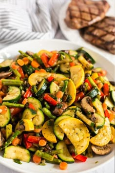 a white plate topped with zucchini and vegetables