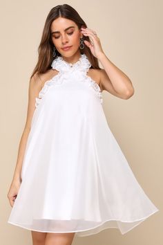 a woman wearing a white dress with ruffles