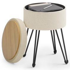 a white stool with black legs next to a round table and a wooden tabletop