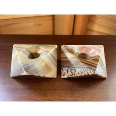 two square shaped dishes sitting on top of a wooden table