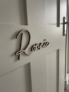 the name rovie is cut out of wood and placed on the wall next to the door