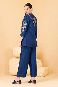 Blue jacket featuring zari embroidered floral motifs embellished with sequins. Comes with plain chanderi pant and inner top.
Components: 3
Pattern: Embroidered
Type Of Work: Zari, Pearl, Sequin
Neckline: Jacket: Open, Top: Band Collar
Sleeve Type: Jacket: Three quarter
Fabric: Top and Pant: Chanderi, Jacket: Modal Satin
Color: Blue
Other Details: 
Attached lining
Length: Jacket sleeve: 18 inches
Weight: 1.5 kgs
Closure: Inner Top: Front button
Occasion: Cocktail,Reception - Aza Fashions Traditional Long Sleeve Pant Set With Zari Work, Embroidered Long Sleeve Palazzo Set For Diwali, Blue Embroidered Long Sleeve Palazzo Set, Festive Chanderi Pant Set With Long Sleeves, Anarkali Style Long Sleeve Pant Set With Chikankari Embroidery, Long Sleeve Palazzo Set With Gota Work, Palazzo Set With Gota Work And Long Sleeves, Festive Long Sleeve Chanderi Pant Set, Bollywood Style Floral Embroidered Pant Set For Eid