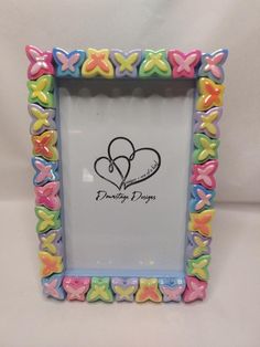 a colorful frame with hearts and butterflies on the bottom is shown in front of a white background