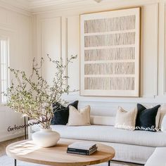 a living room filled with furniture and a large painting on the wall above the couch