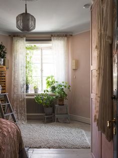 a bedroom with pink walls and white curtains