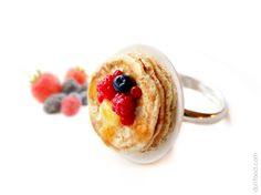 a stack of pancakes sitting on top of a white plate next to berries and raspberries