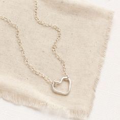 A simple, yet unique necklace to show your love. A simple forged silver heart hangs on silver chain. The heart is attached at two points, so it can change orientation from the side to right side up. Necklace measures 17" - 18 1/2" with lobster clasp and adjustable length chain closure. Small pearls frame the clasp and dangle down the back. Sterling silver. Your jewelry will arrive beautifully gift wrapped in a small box. Multiple items will be combined, unless separate boxes are requested. You will be able to complete this request during check out. If this is a gift being shipped directly to the recipient, you can use the gift box option during check out to include the gift message. If you do not use the gift option, there is no way for me to know these are gifts and your pieces will be wr Everyday Nickel Free Open Heart Necklace, Silver Heart Necklace, Hand Forged, Silver Hand Forged Heart Necklace, Simple Silver Heart Necklace For Anniversary, Hand Forged Silver Heart Necklace, Adjustable Open Heart Necklace With Adjustable Chain, Adjustable Open Heart Necklace, Simple Silver Heart Pendant Necklace, Dainty Adjustable Open Heart Necklace