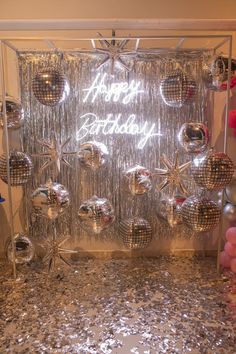 a birthday party with disco balls and streamers in front of a happy birthday sign