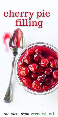 a bowl filled with cherries next to a spoon