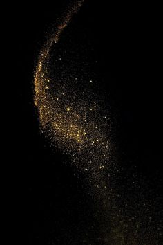 a black background with yellow speckles in the dark, as if it were dust