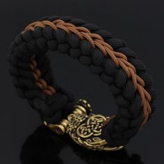 The Preferred Disguise Of Gods During visits to the human world, Odin as well as Thor often takes on the appearance of bear as a disguise. Therefore, bears tend to be looked upon as the forefathers of man in ancient times. Bears symbolize wisdom, strength, and healing that bring balance to seen and the unseen world. This bracelet features a bear paw accent with a Runic inscription at its front face. This type of bracelet is a Paracord bracelet which are also known as survival bracelets and is co Black Viking Jewelry For Outdoor, Black Viking Style Jewelry For Outdoor, Black Viking Style Outdoor Jewelry, Adjustable Black Viking Bracelet, Adjustable Black Bracelets For Outdoor, Handmade Viking Style Black Bracelet, Durable Black Paracord Bracelets, Norse People, Apocalypse Gear