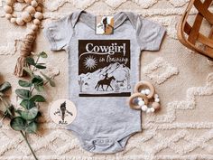 "COWGIRL IN TRAINING (baby bodysuit or kids tee): Designed and handmade in Phoenix - ▲Designed and handmade in Phoenix.▲ ▲The \"PETITE\" kids/baby sister shop of THE PINE TORCH® - our main shop with over 100,000 sales and 25,000 5 star reviews - since 2015! ▲ https://www.etsy.com/shop/ThePineTorch 🌈YEEHAW! Cowgirl in training! How adorable is this retro cowgirl theme design? Perfect for a pregnancy announcement, newborn baby gift, first rodeo top, and beyond! * * * * * * * * * * * * * * * * * * Fitted Short Sleeve Onesie With Custom Print, Cute Fitted Pre-shrunk Onesie, Cute Fitted Onesie With Custom Print, Cowgirl Baby, Phoenix Design, Kids Holiday Gifts, Baby Sister, Newborn Baby Gifts, Holidays With Kids