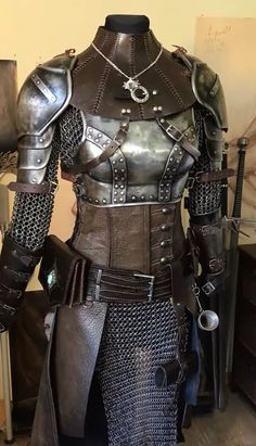 a mannequin dressed in metal armor with chains and spikes on it's chest