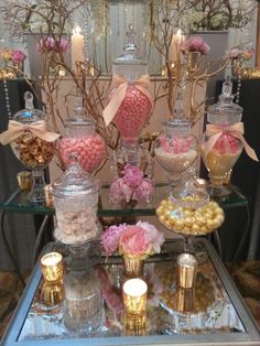 a table topped with lots of candy and candies on top of a glass tray