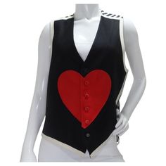 Super fun button down wool vest from Moschino's 'Cheap and Chic' line circa 1990s! The large heart motif in the center of the vest is the star of the show and is so fun to play around with unbuttoning! The back of the vest creates a contrast with a satin striped fabric and an adjustable belt style feature to flatter your figure. Style this over top of a white Miu Miu button down, a pleated Prada skirt and red YSL heel to radiate LOVE wherever the day takes you! In excellent vintage condition, pl Heart Vest, Prada Skirt, Radiate Love, Prada Red, Moschino Jeans, Midsize Fashion, Ysl Heels, Heart Motif, Large Heart