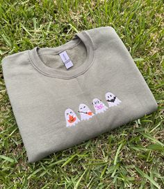 three ghost t - shirts sitting in the grass