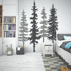 a bedroom decorated in white and black with trees on the wall