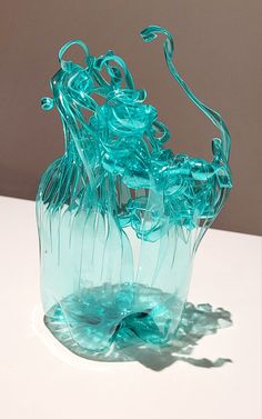 a blue glass vase sitting on top of a white table