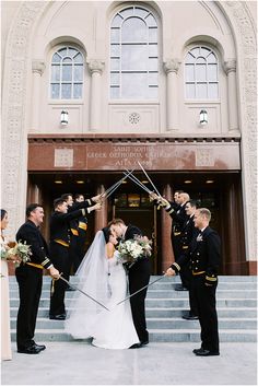 a bride and groom standing in front of a building with their wedding party