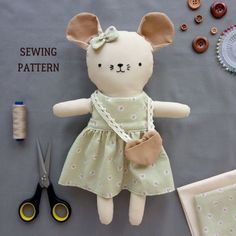 a stuffed animal is sitting next to sewing supplies and buttons on a table with scissors