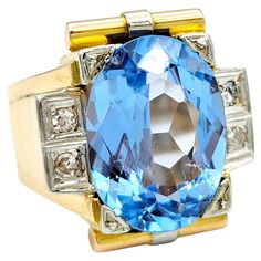 Ring Size: 10 This striking ring boasts a captivating 13.2 carat synthetic oval-cut spinel as its centerpiece, exuding a brilliant blue hue. Framed by four round single cut diamonds and set in an elongated rectangular arrangement, the piece is a unique blend of contemporary and vintage design that models after an art deco style. The meticulous milgrain detailing throughout the piece adds an exquisite touch of intricacy, enhancing its overall elegance. The wide shank is artfully ridged, providing Blue Oval Art Deco Rings, Modern Formal Hallmarked Topaz Ring, Blue Oval Topaz Ring In Art Deco Style, Modern Oval Topaz Ring For Formal Occasions, Luxury Oval Topaz Ring For Formal Occasions, Oval Blue Topaz Diamond Ring For Formal Occasions, Art Deco Oval Topaz Ring With Center Stone, Formal Blue Polished Gemstones, Formal Oval Topaz Ring With Polished Finish