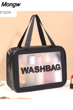 a black bag sitting on top of a white table next to a cup and lipstick