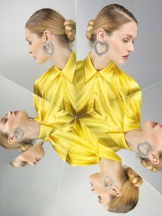 a woman with her hair pulled back in a bun and wearing ear studs is reflected in a mirror