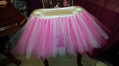 a pink and white tulle skirt sitting on top of a chair