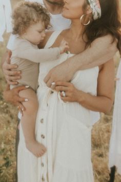 a man and woman holding a baby in their arms