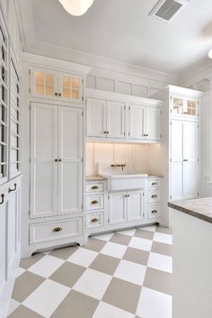 a kitchen with white cabinets and checkered flooring