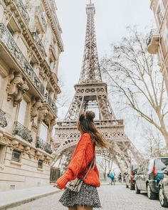 a woman is walking down the street in front of the eiffel tower, paris