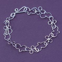 a silver bracelet on a purple background