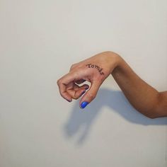 a woman's hand with the word today tattooed on her left thumb and finger