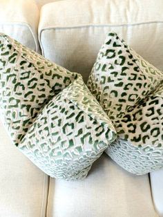 the pillows are stacked on top of each other in different shapes and sizes, along with green spots