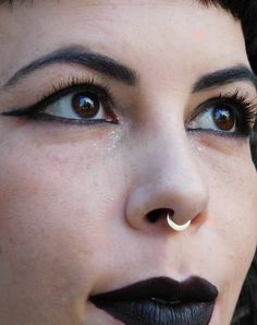 a close up of a woman's nose with piercings