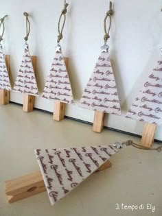 several small wooden christmas trees hanging from hooks