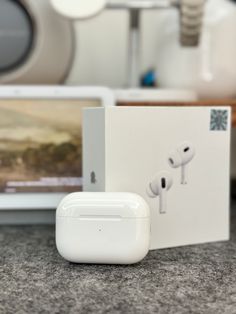 an apple airpods sitting on top of a counter next to a box with ear buds