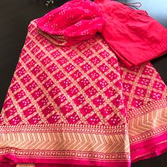 Pink Banaras Bandhni Khaddi Georgette Handloom Saree With A Bell Sleeve Designer Blouse ! Look Stunning And Captivating On This Beautiful Pure Pink Bandhej Banaras Saree. Saree Is Adorned With Gorgeous Gold Zari Jaal Blended With Tie And Die Technique. Ready To Ship Available! 2-3 Days Within Usa! Contact Us For More Details! Khaddi Georgette Blouse Designs, Designer Bandhani Print Pink Saree, Designer Pink Saree With Bandhani Print, Designer Pink Bandhani Print Saree, Pink Salwar Kameez With Dupatta For Traditional Ceremonies, Pink Sharara For Eid And Traditional Ceremonies, Pink Art Silk Sharara For Navratri, Traditional Pink Sharara For Navratri, Pink Semi-stitched Sharara For Traditional Ceremonies