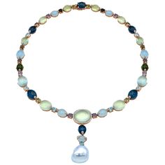 This unique and stunning necklace is guaranteed to be the finishing touch for any occasion. This necklace is made from 34 grams of 18 karat rose gold. Set along the entire necklace are various semiprecious gemstones including aquamarine, London blue topaz, prehnite, multi round semi precious, tourmaline, and diamonds. The end of the necklace is completed with a 17mm baroque south sea pearl. The necklace is secured with a safety lock clasp and is 17.5 inches long and an additional 2 inches hanging with the pearl. The piece with the pearl can be removed for a perfectly round gemstone necklace. There is a total of 145.44 carats of semi-precious stones and 0.66 carats of diamonds. Gold Gemstone Necklace, South Sea Pearl Necklace, Sea Pearl, Modern Necklaces, South Sea Pearls, Stunning Necklace, Jewelry Inspo, Drop Necklace, Modern Jewelry