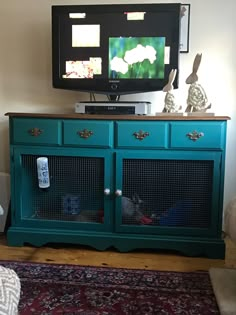 a television on top of a green cabinet in a living room