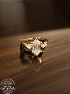 a gold ring with an emerald cut diamond