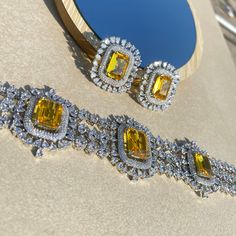 Fancy Yellow Sapphire Canary Diamond Choker Necklace is a masterpiece inspired by the timeless elegance of Harry Winston Jewellery. Adorned with resplendent Fancy Yellow Diamonds, a gracefully designed Yellow Sapphire Necklace, and a Yellow Choker embellished with the brilliance of American Diamonds, it encapsulates the opulence of Indian jewelry craftsmanship in every intricate detail. This exquisite piece is meticulously crafted, making it the perfect complement to enhance the allure of your Bridal Wedding ensemble. *𝐏𝐑𝐎𝐃𝐔𝐂𝐓 𝐃𝐄𝐓𝐀𝐈𝐋* * Material: Brass * Plating: White Rhodium Plated * Stone: AAA-quality CZ yellow diamond & canary diamond. *𝐃𝐈𝐌𝐄𝐍𝐒𝐈𝐎𝐍𝐒*  Necklace * Weight: 61 gm * Design Length: 8  inches * Total Length with Closure: 15.75 inches * Width: 1.7 Inches Luxury Wedding Jewelry Sets With Gemstones, Elegant Yellow Bridal Necklace For Party, Elegant Yellow Bridal Necklace For Formal Occasions, Yellow Gold Jewelry With Yellow Sapphire For Wedding, Luxury Citrine Necklace For Wedding, Luxury Yellow Diamond Jewelry, Yellow Fine Jewelry Necklace For Wedding, Yellow Crystal Necklace For Weddings, Elegant Yellow Jewelry Sets For Weddings