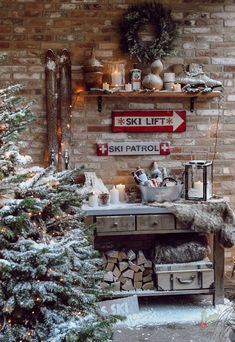 a christmas tree in front of a brick wall with ski lift sign above it and snow on the ground