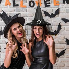 two women dressed up in witches costumes posing for the camera