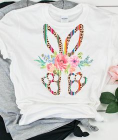 a t - shirt with flowers on it next to some other items