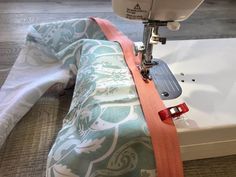 the sewing machine is on top of the fabric to sew it's edges