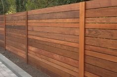 a wooden fence next to a brick sidewalk