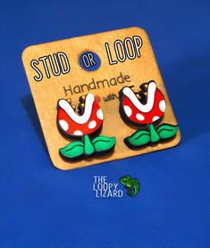 "Add a bite of gaming nostalgia to your style with these Piranha Plant earrings, bringing a dash of pixelated charm and side-scrolling fun to your ensemble that'll have you ready to jump, stomp, and power-up through fashion levels like a true Mushroom Kingdom hero!" Piranha Plant Stud/Dangle Earrings - Video Game Earrings - Retro Earrings -  Flower Earrings - Wonderland Earrings  - Gift for her/him 🌟 Sparkle and Shine with Our Exquisite 'Loopy' Earrings! 🌟 Looking to add a touch of quirkiness Game Earrings, Keychains Accessories, Gaming Nostalgia, Piranha Plant, Earring Video, Mushroom Kingdom, Plant Earrings, Retro Earrings, Quirky Earrings